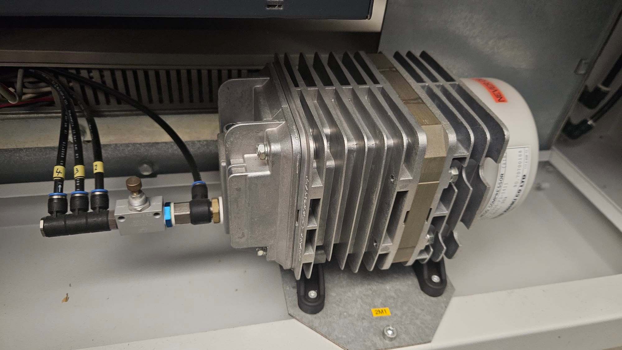 Finned aluminium air compressor mounted inside the machine with black air hoses