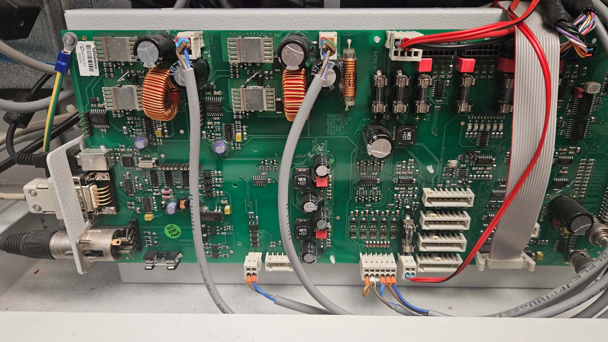 Green circuit board with two copper toroidal inductors, heatsinked components and grey ribbon cables