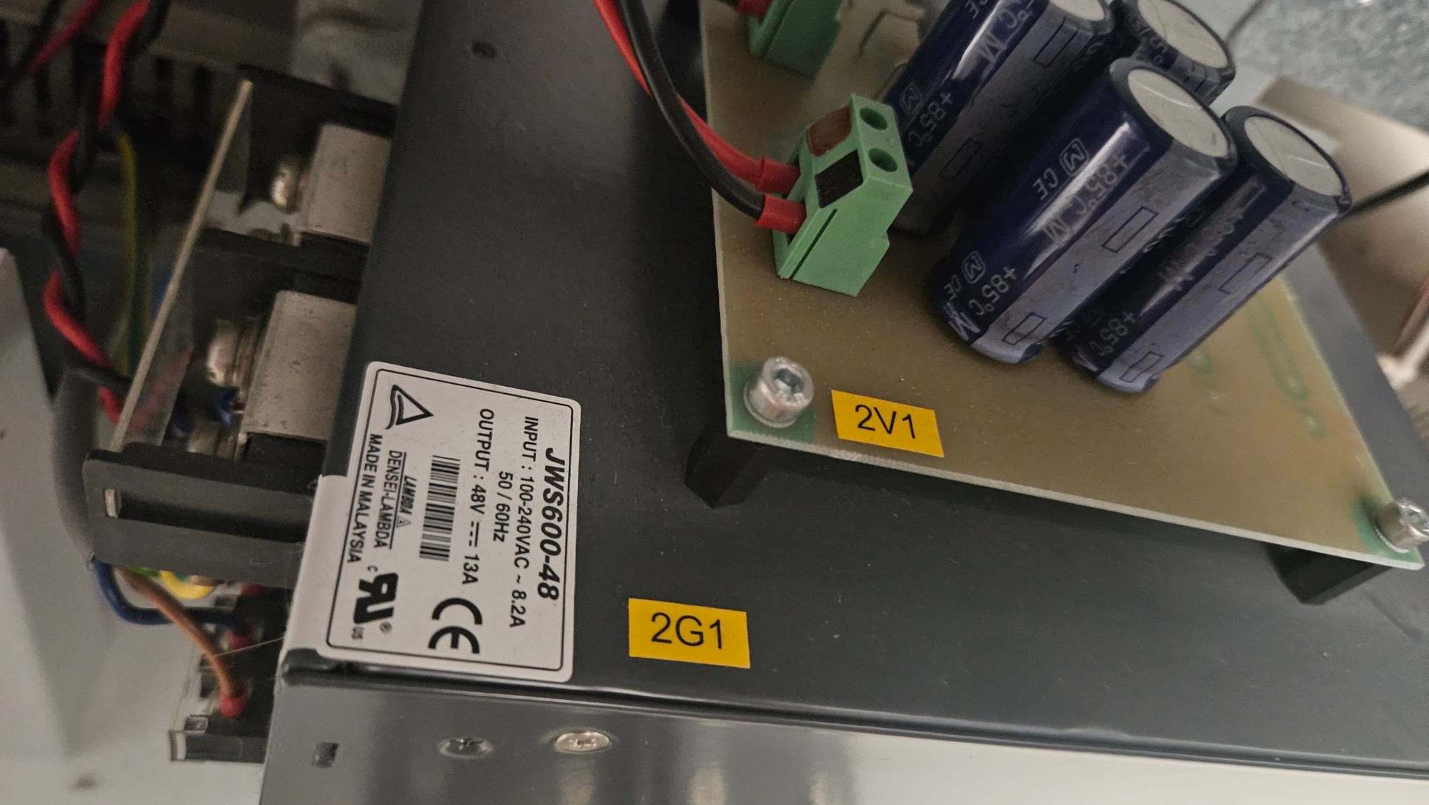 Densei-Lambda JWS600-48 power supply labelled 2G1 next to a small board labelled 2V1 with three large capacitors